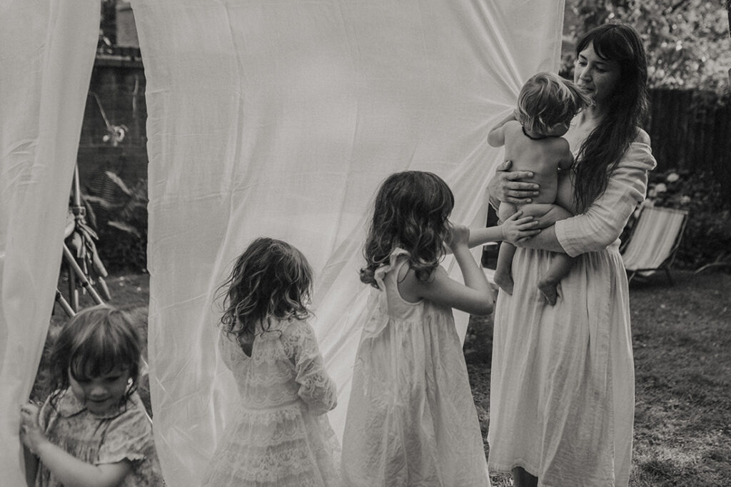 Photo noir et blanc d'une maman avec ses filles photographiée par Coralie Monnet photographe à Nantes