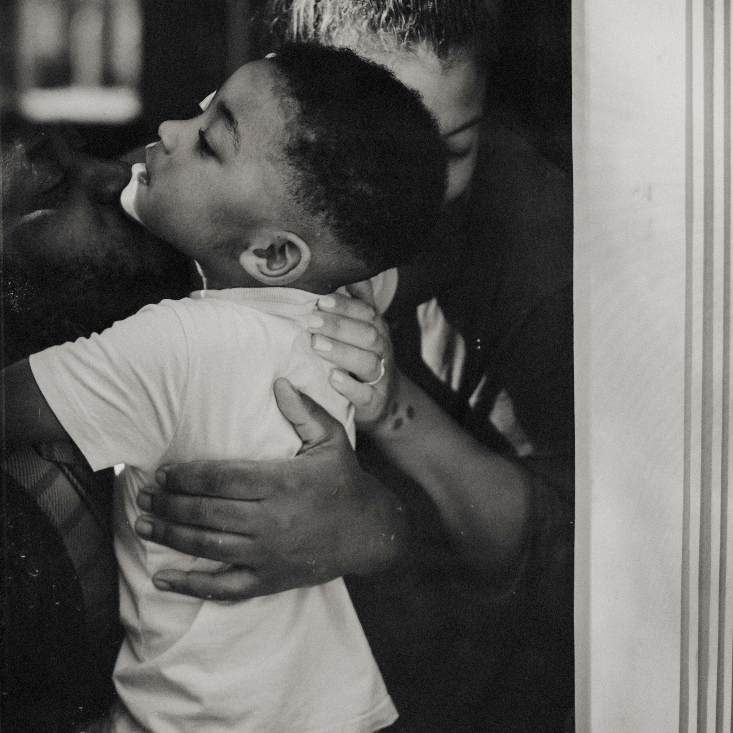 Portrait serré de parents serrant leur enfant dans leurs bras lors d'uune séance famille