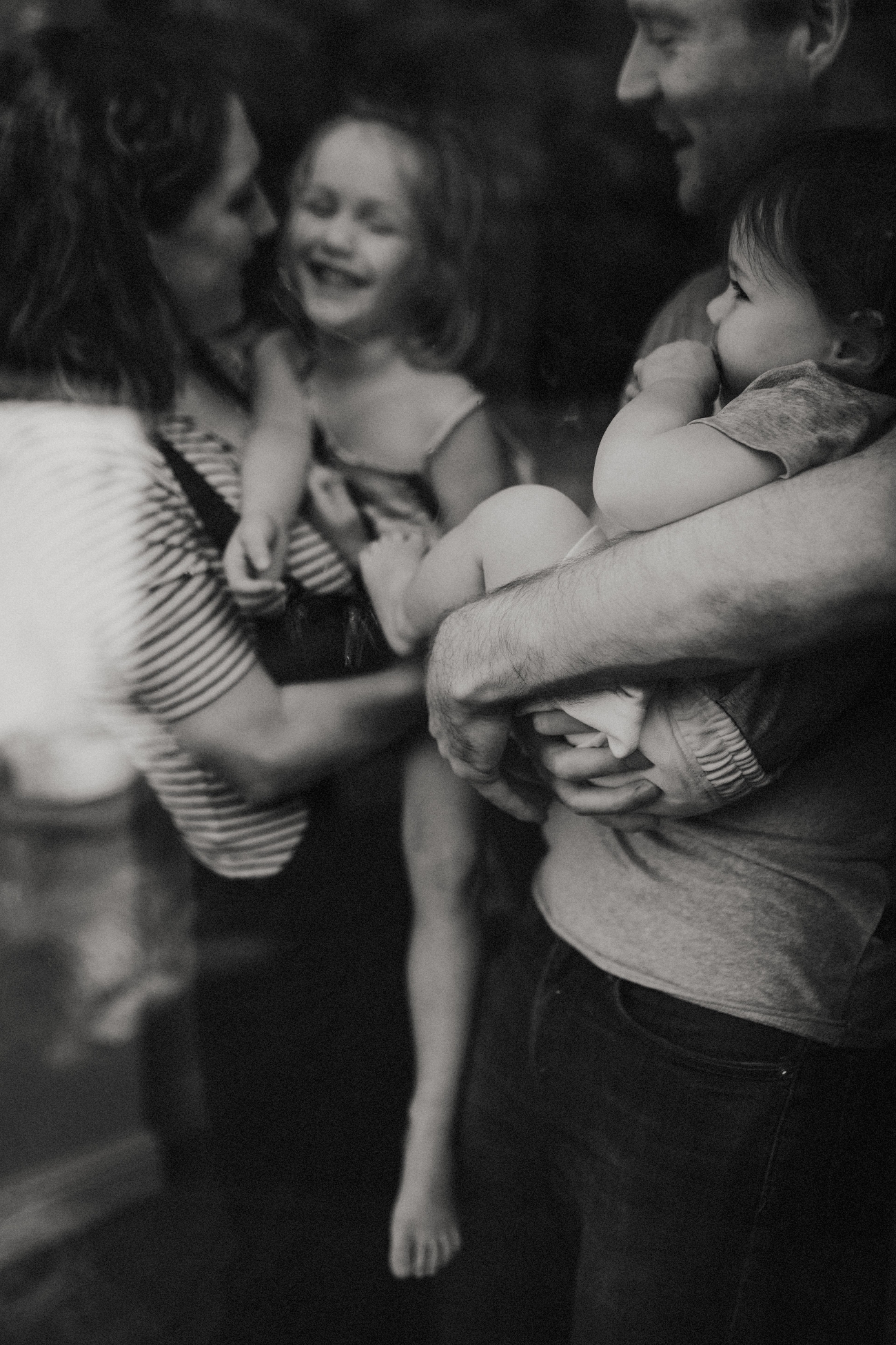Photo noir et blanc d'une famille prise à traves la fenêtre par une photographe à Nantes
