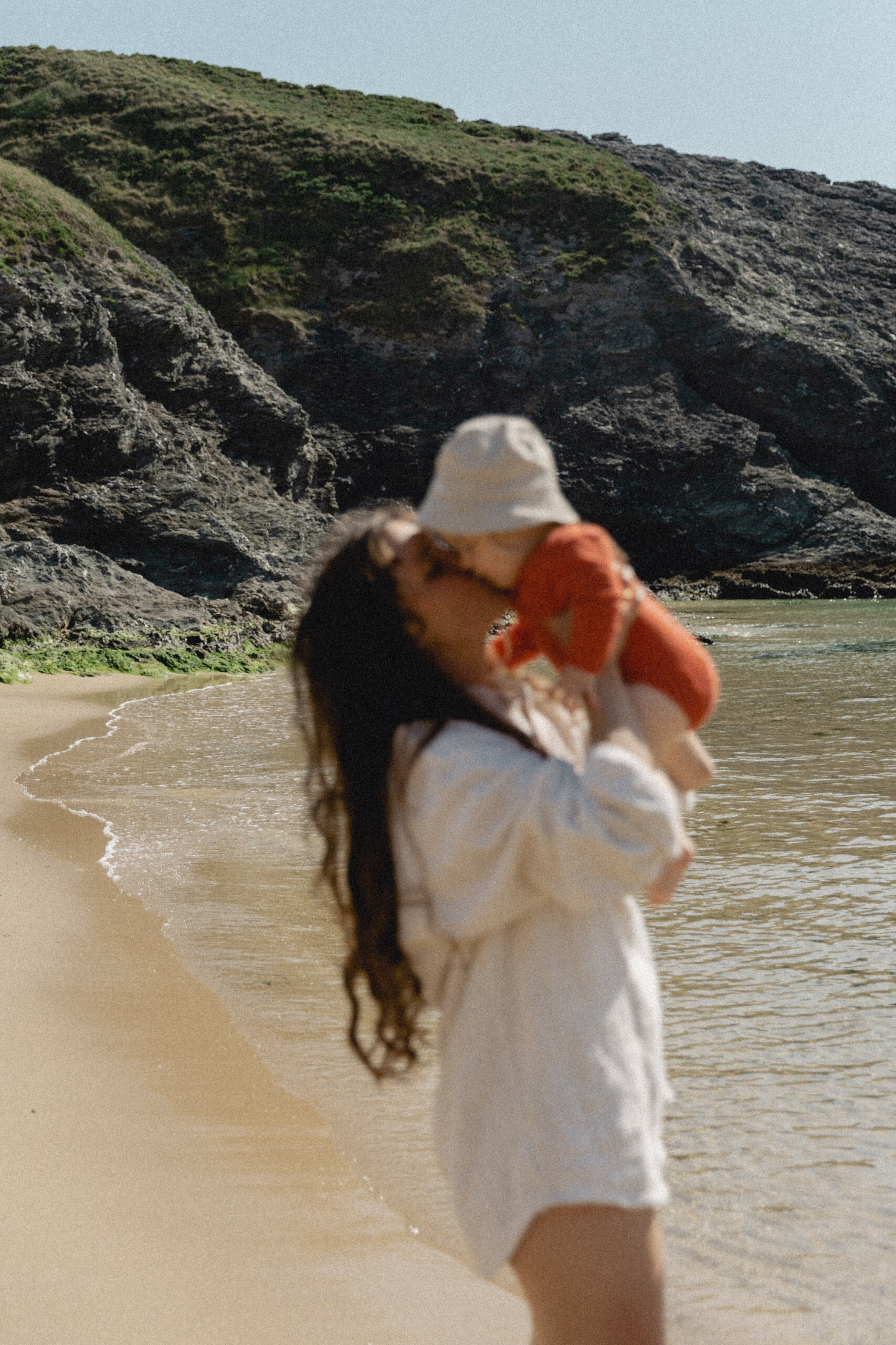 Une maman sur la plage embrassant sa fille pendant une séance famille dans le morbihan