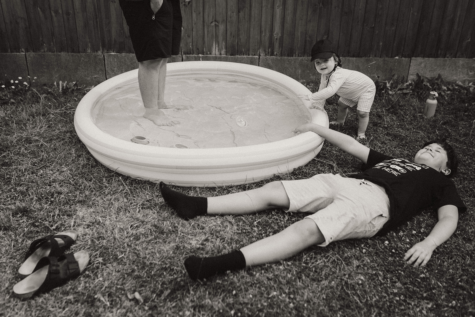photo en contre plongée d'une d'une famille se relaxant près d'une piscine gonflable dans leur jardin à Nantes