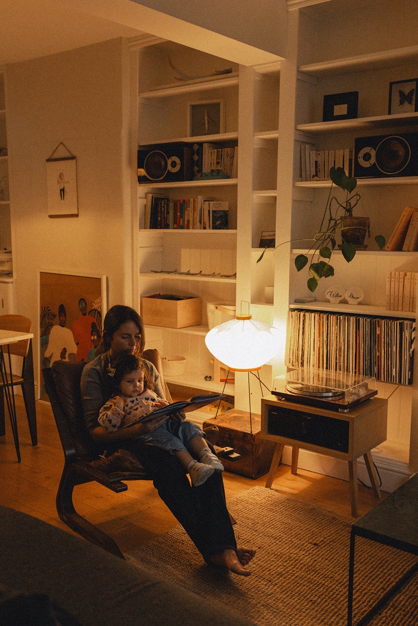 Mother reading a book to her child in the warm atmosphere of their London home during a motherhood session