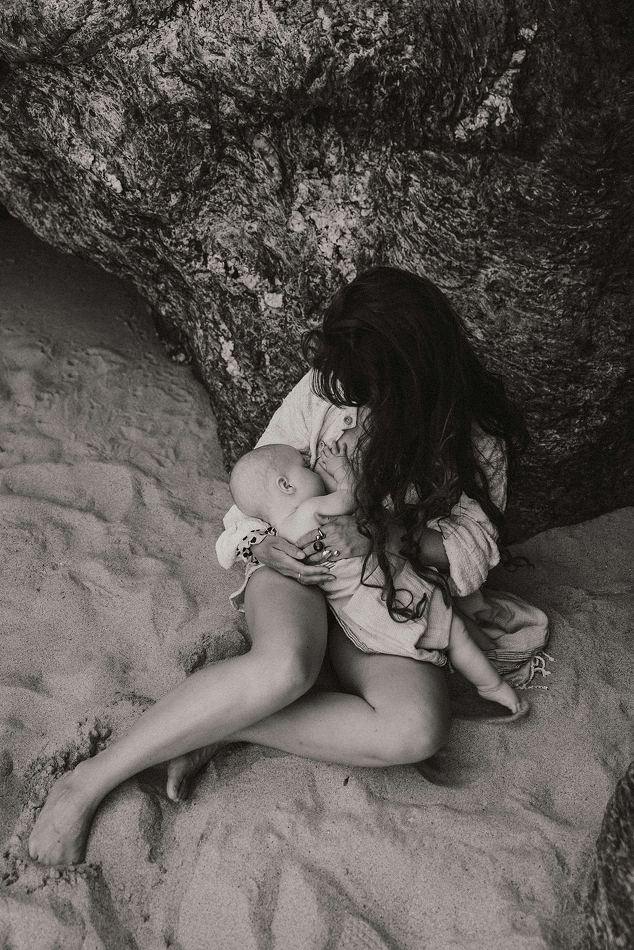 Maman qui allaite sur une plage en bretagne lors d'une séance photo