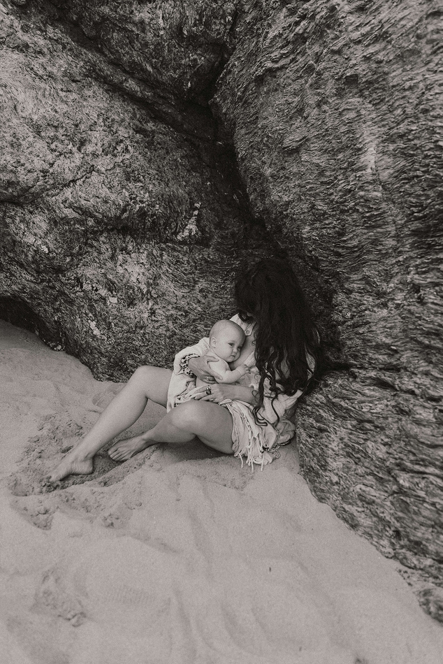 Maman qui allaite sur bébé sur la plage lors d'une séance photo famille